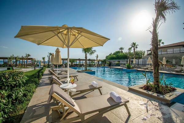 Pool-Loungebereich im Seaden Quality Resort & Spa mit Sonnenschirmen und Liegestühlen.