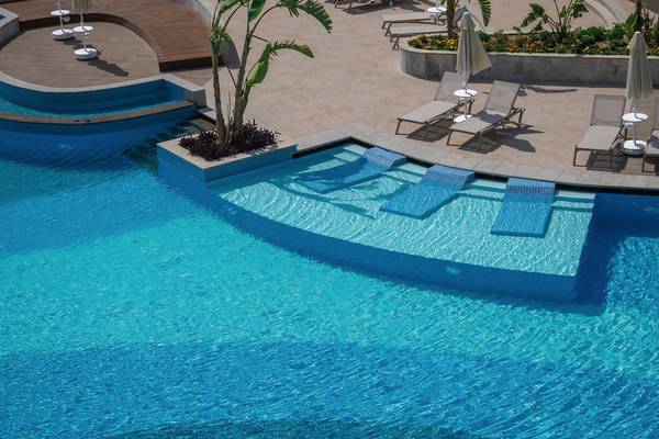 Luftaufnahme des Pools im Seaden Quality Resort & Spa mit Lounge-Liegestühlen und Pflanzen