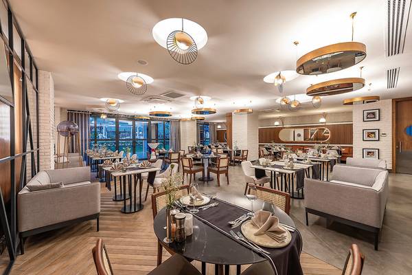 Innenansicht des Restaurants im Seaden Quality Resort & Spa mit modernen Möbeln und großen Fenstern.