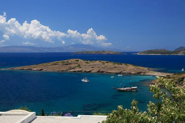 Aussicht auf das Larissa Bodrum View Resort mit Booten im Wasser und Inseln im Hintergrund.