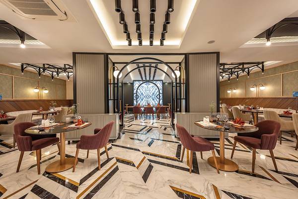Innenansicht des Restaurants im Seaden Quality Resort & Spa mit Marmorboden und modernen Möbeln.