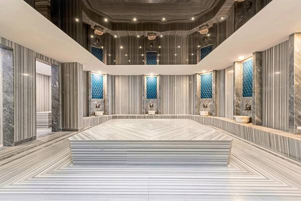 Innenbereich der Sauna im Seaden Quality Resort & Spa mit Marmorwänden und Bänken.