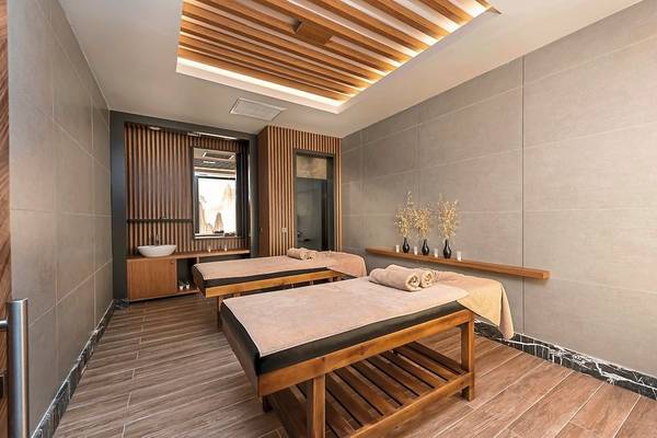 Massagebereich im Seaden Quality Resort & Spa mit zwei Massagetischen und Holzelementen.