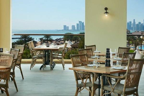Terrasse des Intercontinental Doha Beach & Spa Hotels mit Blick auf das Meer und die Stadt.