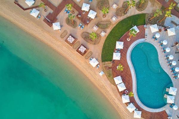 Luftaufnahme des Intercontinental Doha Beach & Spa mit Pool und Sonnenschirmen am Strand