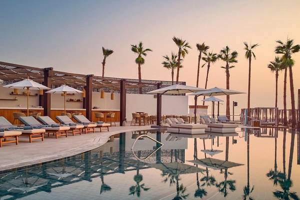 Pool-Loungebereich des Intercontinental Doha Beach & Spa Hotels mit Liegestühlen und Sonnenschirmen