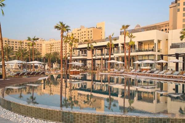 Außenansicht des Intercontinental Doha Beach & Spa Hotels mit Swimmingpool und Loungestühlen