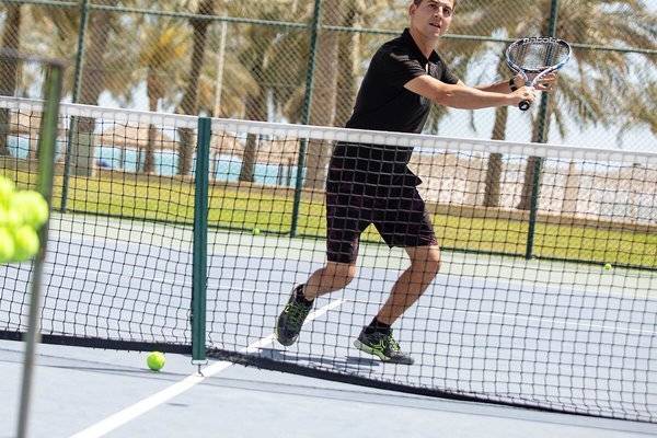 Tennisspieler auf dem Tennisplatz des Intercontinental Doha Beach & Spa Hotels