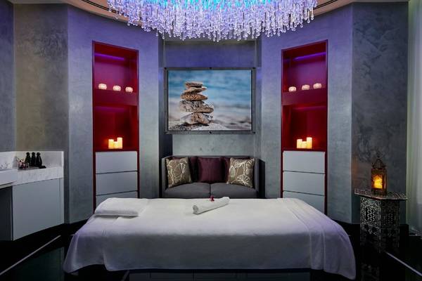 Luxuriöses Massagezimmer im Intercontinental Doha Beach & Spa mit Kristallleuchter, Fototapete und Loungesofa.