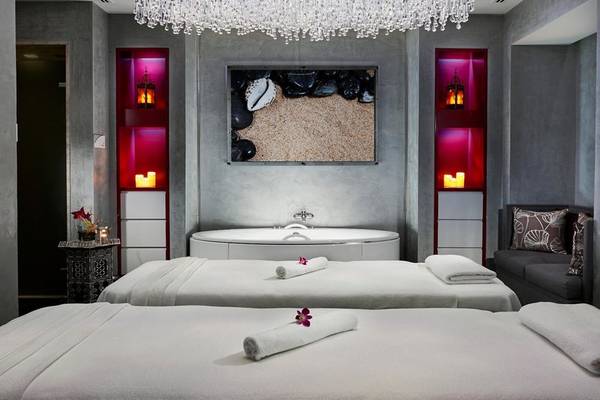Spa-Behandlungsraum im Intercontinental Doha Beach & Spa mit zwei Massageliegen, einem Whirlpool und einem Fernseher an der Wand.