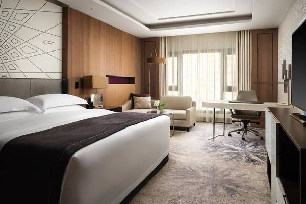 Interkontinentales Doha Beach & Spa Hotel Zimmer mit Bett, Schreibtisch und Sofa.