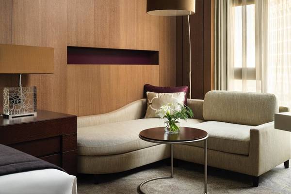 Interconti Doha Beach & Spa Hotelzimmer mit Couch, Tisch und Lampen.