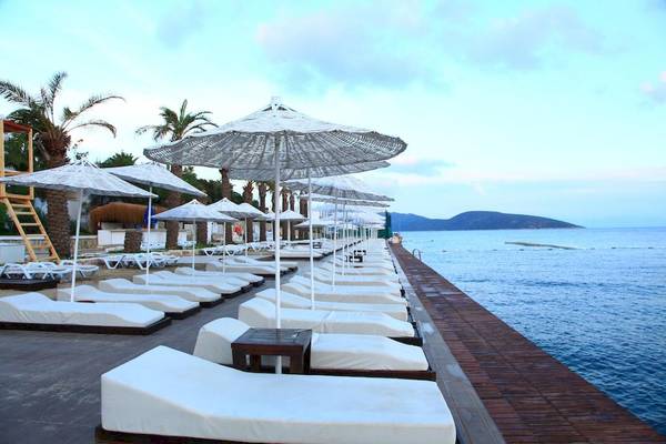 Pool-Lounge-Bereich des Larissa Bodrum View Resorts mit weißen Liegestühlen und Sonnenschirmen.