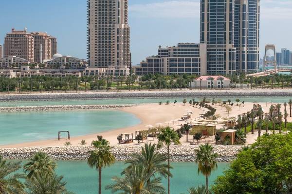 Stadtansicht von Doha mit dem Ritz-Carlton Hotel im Vordergrund und einer Bucht im Vordergrund.