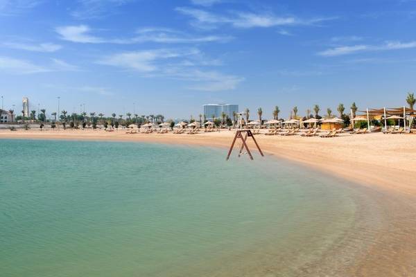 Strand mit Palmen und Strandliegen im Ritz-Carlton Doha
