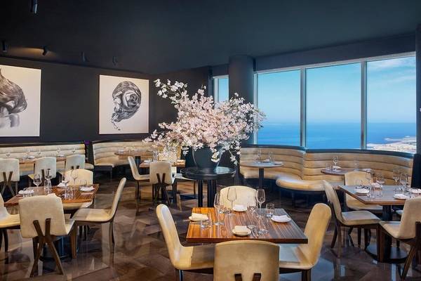 Restaurant im Ritz-Carlton Doha mit Blick auf das Meer und Blumendekoration.