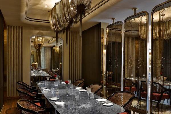 Innenbereich des Ritz-Carlton Doha mit elegantem Esstisch, spiegelnden Wänden und moderner Einrichtung.