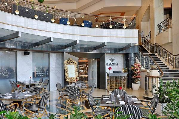 Der Loungebereich im Ritz-Carlton Doha mit Tisch, Stühlen und Pflanzen.