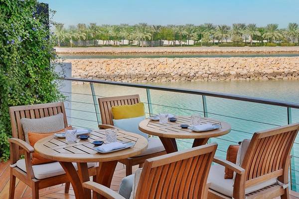 Terrasse des Ritz-Carlton Doha mit Blick auf das Meer und grüne Landschaft