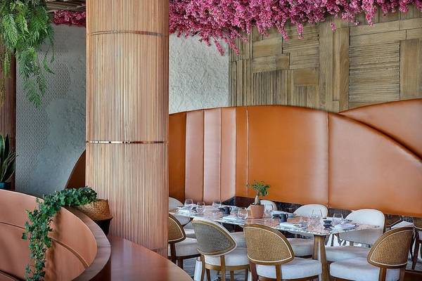 Innenbereich des Ritz-Carlton Doha Hotels mit braunen Ledersitzen, Holzwänden und pinken Blumen