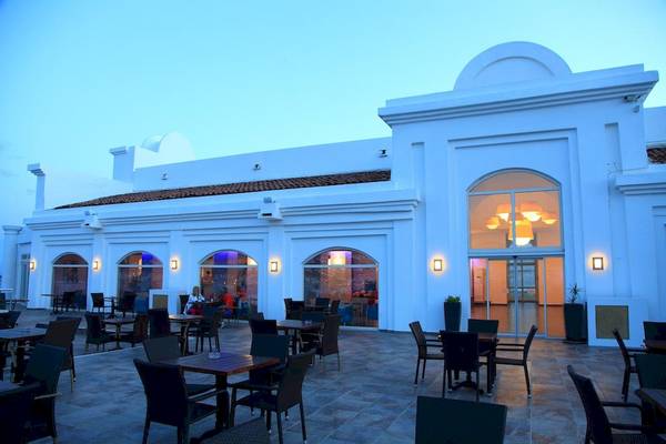 Außenterrasse des Larissa Bodrum View Resorts mit runden Fenstern und abendlicher Beleuchtung.