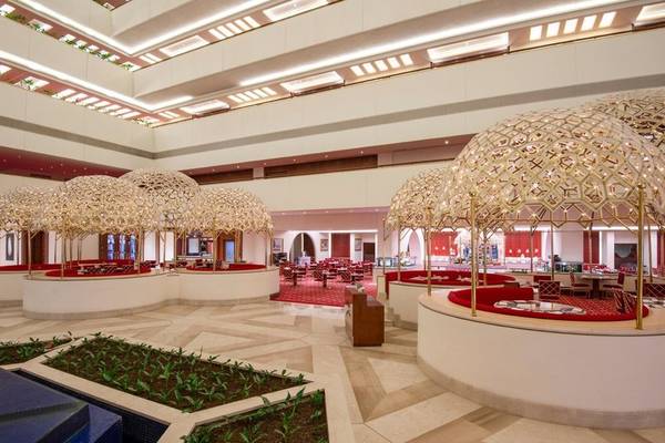 Innenbereich des Sheraton Doha Resort Convention Hotel mit modernen Sitzbereichen und goldenen Pavillons.
