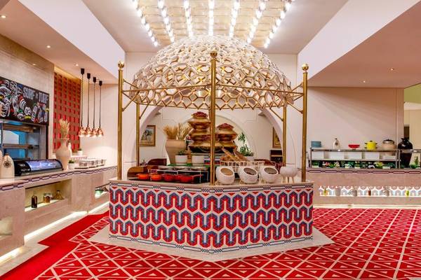 Innenbereich des Sheraton Doha Resort Convention Hotel mit einem goldenen Pavillon, rotem Teppich und geometrischen Mustern.