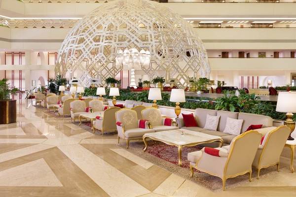Lobby des Sheraton Doha Resort Convention Hotel mit großer strukturierter Decke und eleganten Möbeln.