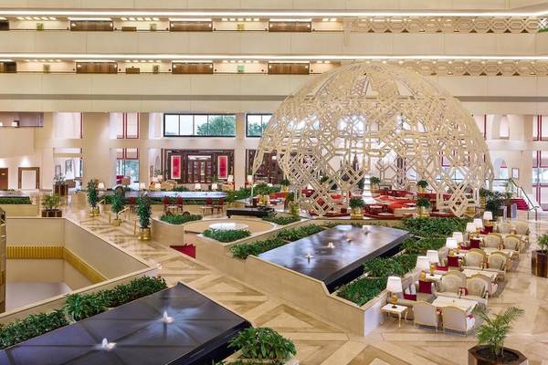 Innenansicht des Sheraton Doha Resort Convention Hotel mit einer großen Struktur und mehreren Sitzbereichen.