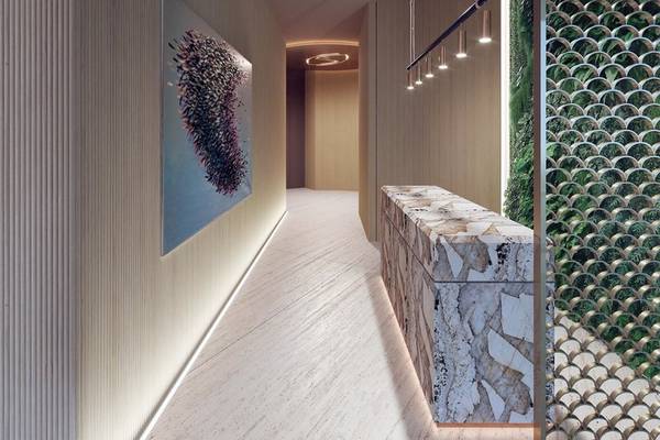 Eingangsbereich des Sheraton Doha Resort Convention Hotel mit Marmortheke und blauem Wandbild