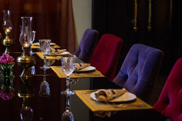 Speisesaal im Sharq Village und Spa, A Ritz Carlton Hotel mit gedeckten Tischen und Stühlen.