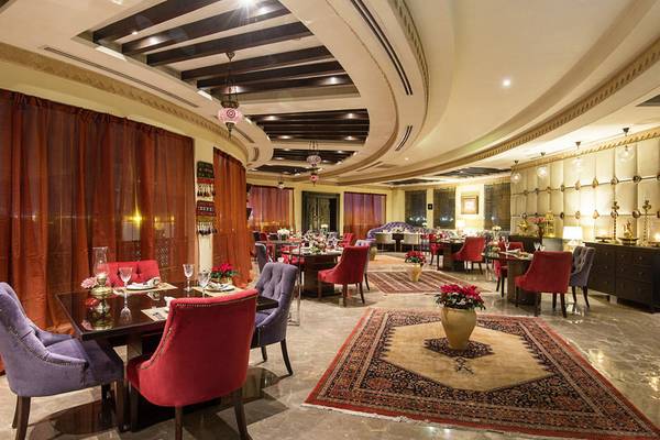 Innenansicht des Restaurants im Sharq Village und Spa, Ritz Carlton Hotel mit eleganten Möbeln und Tischdekoration.