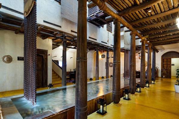 Innenansicht des Sharq Village and Spa, A Ritz Carlton Hotel mit einem langen Wasserbecken.