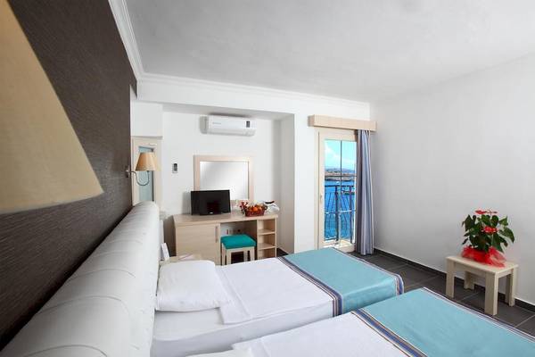 Doppelzimmer im Larissa Bodrum View Resort mit zwei Betten, Klimaanlage, Schreibtisch und Meerblick.