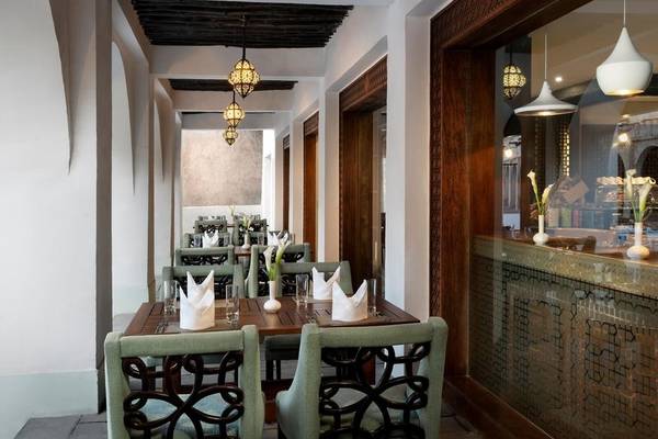 Innenansicht des Restaurants im Souq Waqif Boutique Hotels mit gedeckten Tischen und traditioneller Beleuchtung.