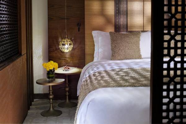 Schlafzimmer im Souq Waqif Boutique Hotels mit Bett, gelben Blumen und Tischlampen.
