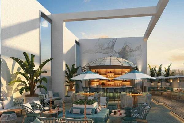 Terrasse des Embassy Suites By Hilton Doha Old Town mit Tischen, Stühlen und Sonnenschirmen