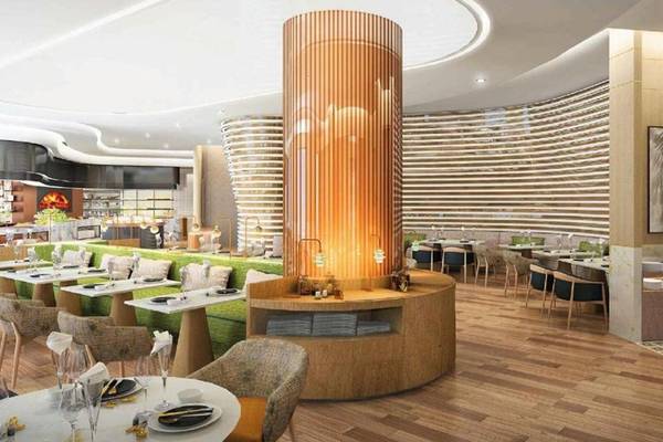 Innenraum des Restaurants im Embassy Suites By Hilton Doha Old Town mit grünen Bänken und Holzboden.