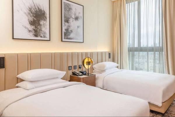 Doppelbett-Zimmer im Embassy Suites By Hilton Doha Old Town mit moderner Einrichtung und Stadtblick.