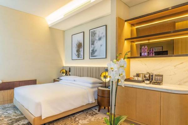 Schlafzimmer im Embassy Suites By Hilton Doha Old Town mit Doppelbett, Nachttischen und Dekor