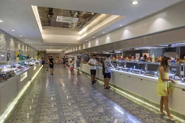 Ein Buffetbereich im Royal Taj Mahal Hotel mit Gästen, die Speisen auswählen.