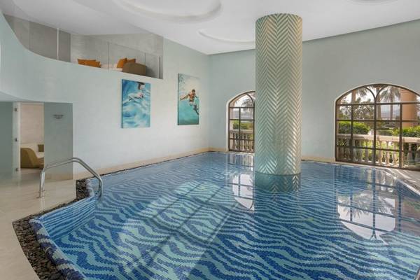 Innenpool des Marsa Malaz Kempinski, The Pearl mit blauem Wasser und weißen Wänden.