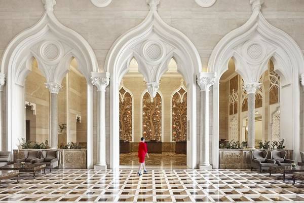 Person in rotem Kleid geht durch die Lobby des Marsa Malaz Kempinski, The Pearl.