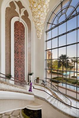 Marsa Malaz Kempinski Hotel Innenansicht des Treppenhauses mit Musterwand und Blick auf die Außenanlage.