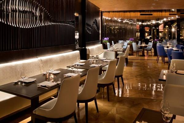 Innenansicht des Restaurants im Marsa Malaz Kempinski, The Pearl mit gedeckten Tischen und Stühlen.