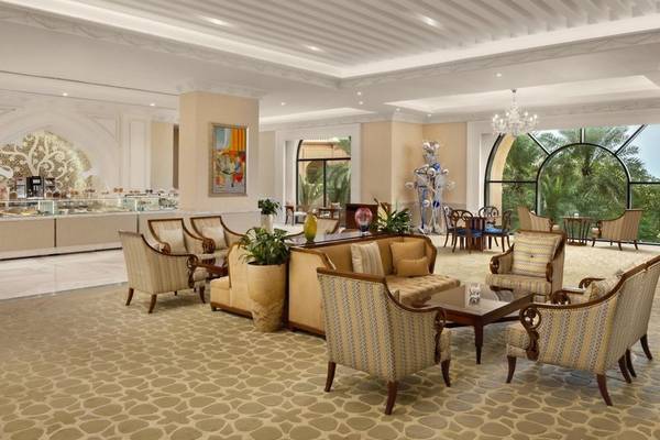 Hotellobby des Marsa Malaz Kempinski, The Pearl mit gemustertem Boden, Möbeln und Pflanzen.