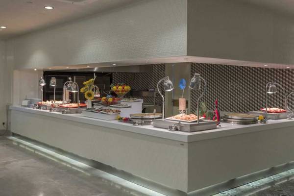 Buffetbereich im Royal Taj Mahal Hotel mit verschiedenen Gerichten und Früchten.