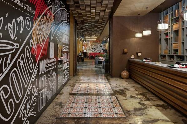Innenbereich des Marsa Malaz Kempinski Hotels mit Wandmalereien und Fliesenboden.