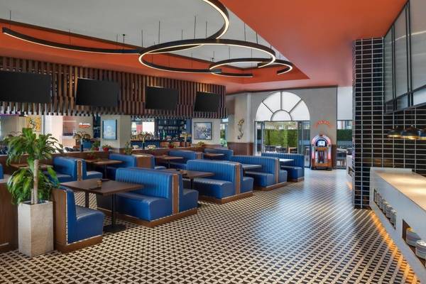 Innenbereich des Restaurants im Marsa Malaz Kempinski, The Pearl, mit blauen Sitzbänken, schwarzen Tischdecken und geometrischen Bodenfliesen.