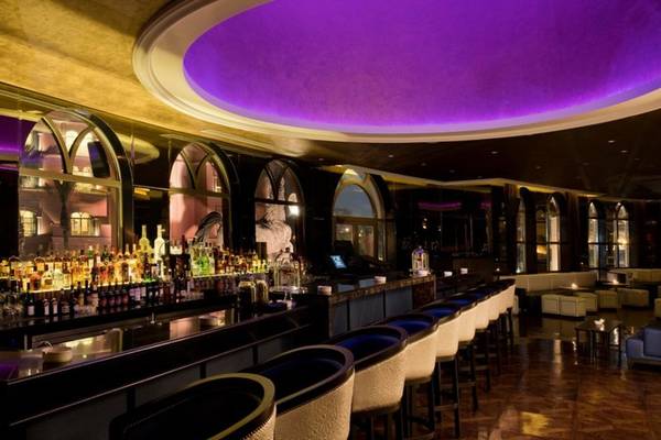 Die Bar des Marsa Malaz Kempinski, The Pearl Hotel mit vielen Flaschen und violetter Beleuchtung.